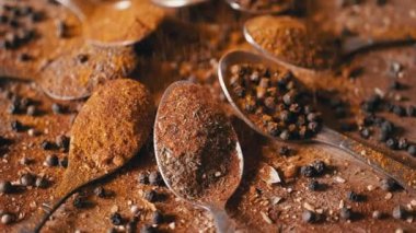 Dökülen Baharatlar ve Renkli Baharatlar Tahta Arkaplanda Dönüyor. Bol miktarda kurutulmuş Hint otları. Baharat, karabiber, dereotu, paprika, zerdeçal, kekik. Malzemeler. Doku.