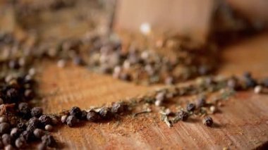 Renkli Dönen Arkaplan 'da Tahta Spatula ile karıştırılmış Hint Baharatları. Kapatın. Yığın. Baharatlı biberler, kurutulmuş otlar, dereotu, paprika, zerdeçal, kekik. Doku. Bulanık. Kurutulmuş baharatlar..