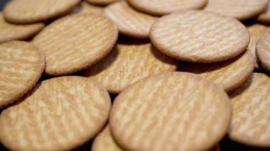 Yaklaş, Yuvarlak Kıtır Kurabiye Turntable 'da Dönüyor, Arka plan. Lezzetli krakerler. Üst Manzara. Sağlıklı gıda konsepti. Tatlı hamur işleri. Yemek arkaplanı. Satılık. Doku. Yavaş çekim.