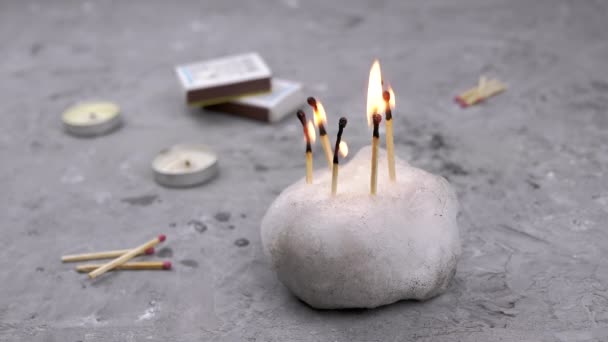 Πολλά Burning Matches Στο Χιόνι Γκρι Μπετόν Φόντο Σκορπισμένα Κεριά — Αρχείο Βίντεο