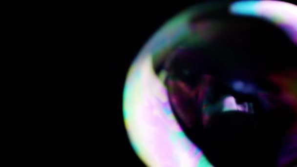 多色のビッグソープバブルが空の黒い背景で成長し 破裂します スプラッシュ 暗い空間で透明な虹のバブル 燃えるような動き 集中しろ テクスチャ 抽象的 スローモーション隔離された — ストック動画