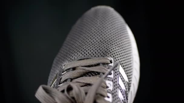 Handrotatie Van Black Textile Perforated Sneakers Een Zwarte Achtergrond Textuur — Stockvideo