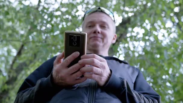 Närbild Happy Man Skriva Ett Meddelande Smartphone Skogen Naturen Bottenvy — Stockvideo