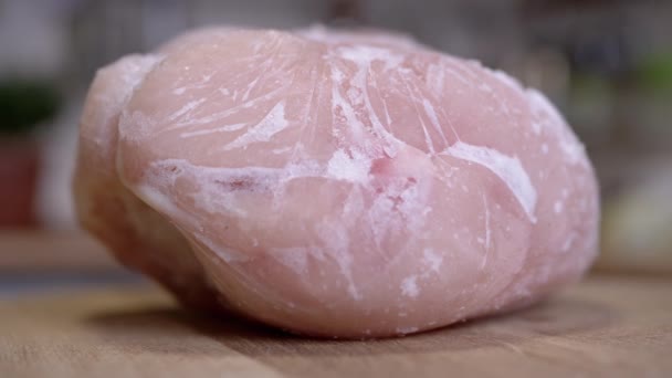 回転する背景に氷の地殻で覆われた冷凍肉の大片 閉めろ 氷の雪 氷の地殻と冷凍鶏の切り身 テクスチャ 食料が破壊される 隔離されてる 選択的フォーカス — ストック動画