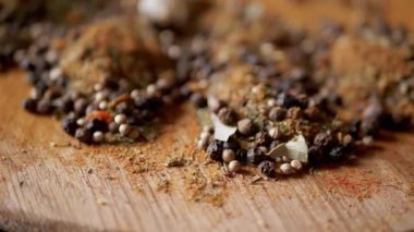 Değişen ahşap arka planda çeşitli çok renkli Hint baharatları serpiştirilmiş. Parlak aromatik kuru baharatların bileşimi. Baharatlı biberler, kurutulmuş bitkiler, dereotu, paprika, zerdeçal, kekik.