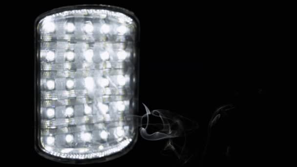煙の雲が光る懐中電灯の黒い背景に立ち上がります 煙の質感 エネルギー危機 省エネルギーの概念 抽象的 電球で主導スポットライト ぼやけた背景 — ストック動画