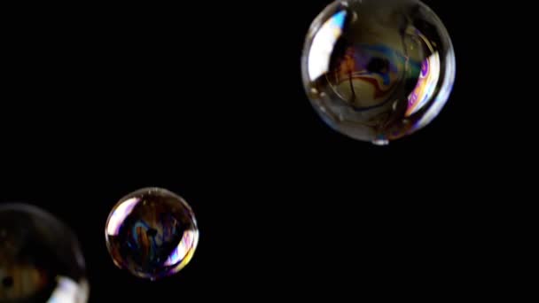 カラフルな石鹸の泡は 隔離された黒の背景に空の空間に飛びます 多くの虹の透明な泡がランダムに回転し 浮遊し 落下する 燃えるような動き 選択的フォーカス 抽象的 ゲームだ スローモーション — ストック動画