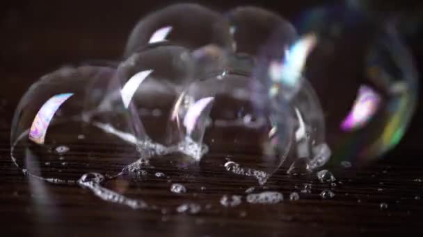 Großaufnahme Kleben Viele Bunte Seifenblasen Auf Einer Braunen Holzoberfläche Transparente — Stockvideo