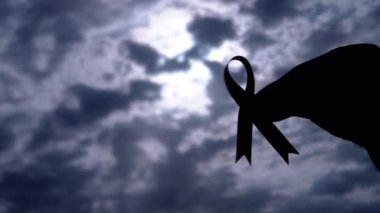 Kadın Ellerinin Silueti Gri Bulutların Arkasında Pembe Kurdele Gösteriyor. Göğüs kanseri sembolü olan bir el penceredeki kümülüs bulutlarının arasından güneş ışığına ulaşır. Ekim ayı.