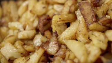 Kızarmış patates ve altın hamurlu kızartma tavası ve döner arka plan. Kapatın. Doku. Ev mutfağında pişirilmiş baharatlarla yağda kızartılmış patates kızartması. Yan görüş. Yavaş çekim.