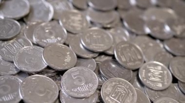 Yakın plan, Dönen Arkaplanda Bir sürü gümüş sikke. Para geçmişi. Ukrayna kuruşları, kopekler. Hareket ediyor, dönüyor. Finansal kriz, birikim, birikim. Ukrayna amblemi, damga.