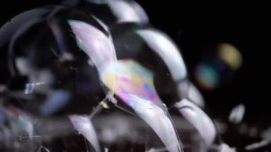 Yakından bakınca, bir sürü renkli sabun köpüğü kahverengi tahta bir yüzeye yapışmış. Şeffaf gökkuşağı kabarcıkları köpüklü sinek, bağlantı, patlama. Kabarcık sürüsü. Su sıçrattı. Yapı. Bulanık hareket. Soyut.