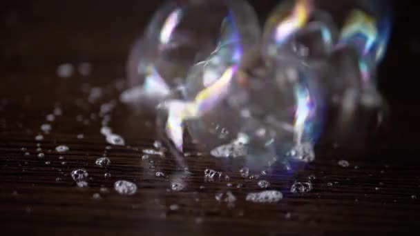 Großaufnahme Kleben Viele Bunte Seifenblasen Auf Einer Braunen Holzoberfläche Transparente — Stockvideo