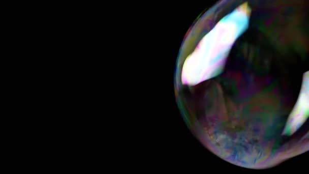 カラフルな石鹸の泡は 隔離された黒の背景に空の空間に飛びます 多くの大規模な 小さな虹の泡がランダムに回転し フロート バースト 燃えるような動き 集中しろ 抽象的 スローモーション — ストック動画
