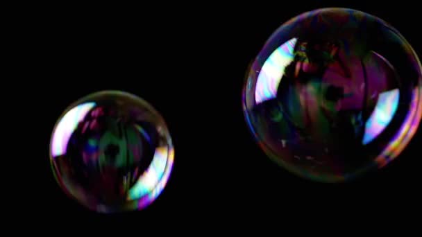近距离观察 大大的彩色肥皂泡在黑色背景下缓缓飘扬 透明彩虹气泡在空旷的空间 模糊的动议 集中精神纹理 慢动作 — 图库视频影像