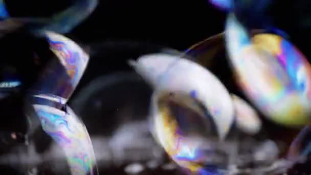 近距离观察 在木制表面上有很多彩色的肥皂泡在一起 透明的彩虹气泡 泡沫飞舞 泡泡束 模糊的动议 黑色背景 — 图库视频影像