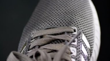 Siyah Tekstil Performanslı Spor Ayakkabıları El Dönüşü. Doku, ağ, delikler, malzeme. Siyah arka plan, bağcıklar, ayak parmağı. Görüntü. Formda olmak için kadın ya da erkek ayakkabısı. İzole edilmiş.