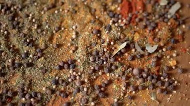 Değişen ahşap arka planda çeşitli çok renkli Hint baharatları serpiştirilmiş. Baharat, karabiber, kurutulmuş otlar, dereotu, paprika, zerdeçal, kekik. Yemek pişirmek için güzel kokulu baharatlar..