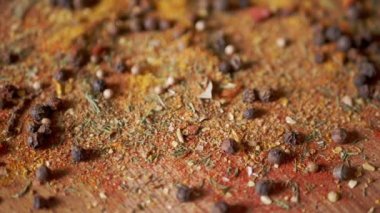 Değişen ahşap arka planda çeşitli çok renkli Hint baharatları serpiştirilmiş. Baharat, karabiber, kurutulmuş otlar, dereotu, paprika, zerdeçal, kekik. Yemek pişirmek için güzel kokulu baharatlar..
