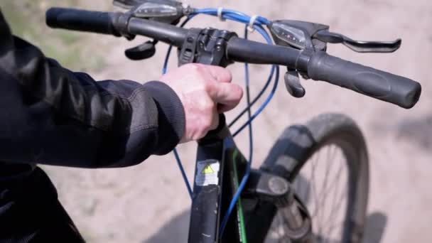 Ukraine Kamenskoe 2023 閉じる 森の中のサンディ パスに沿って自転車を押す男性の手 観光客は自転車を転がす 晴れた暖かい夏の日 健康的なライフスタイル スポーツ — ストック動画