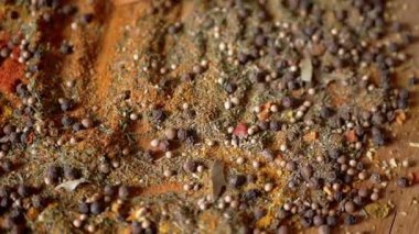 Renkli Dönen Arkaplan 'da Tahta Spatula ile karıştırılmış Hint Baharatları. Kapatın. Baharatlı biberler, kurutulmuş otlar, dereotu, paprika, zerdeçal, kekik. Doku, şekil. Palet kurutulmuş baharat..