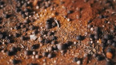 Renkli Baharatların Dönen Ahşap Arkaplanda Kurutulmuş Baharatlar Şelalesi. Kapatın. Ağır çekim. Dağınık Hint baharatı karışımı, siyah biber, zerdeçal, paprika, kişniş, kekik. Arkaplan, doku.