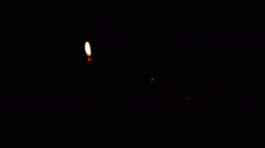 Yaklaş, Yanan Mum 'un Kara Arkaplanı' ndaki Karanlık Oda 'da titreşen lamba. Tungsten akkor ampulü, sıcak ve kapalı. Enerji krizi. Elektrik var. Elektrik kesintisi. Kesinti. Savaş.