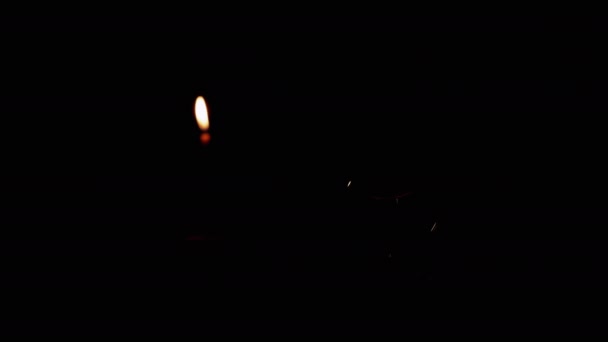 閉じる バーニングキャンドルの黒の背景に暗い部屋でフリッカーランプ 暖かい光をオンにしたタングステン白熱電球 エネルギー危機 電気だ 停電だ 停電だ — ストック動画
