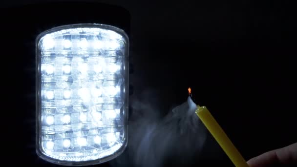 Person Bläst Brennende Kerze Auf Schwarzem Hintergrund Einer Eingeschalteten Taschenlampe — Stockvideo
