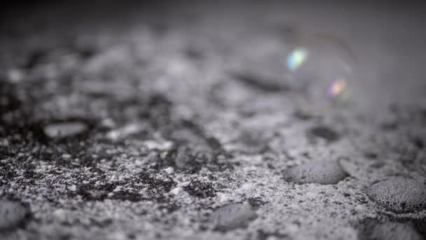 粉状和泡沫白色模糊背景下的肥皂泡飞散和爆裂 透明的彩虹气泡在雪地表面爆炸 慢动作 — 图库视频影像