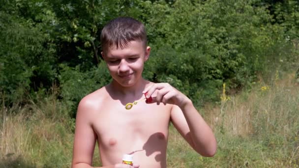 Smiling Boy Naked Torso Blowing Soap Bubbles Nature Sunlight Закрывай — стоковое видео