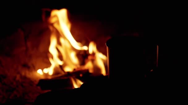 Gece Bulanık Kamp Ateşinin Arkaplanındaki Sıcak Bir Fincan Kahvenin Silueti — Stok video