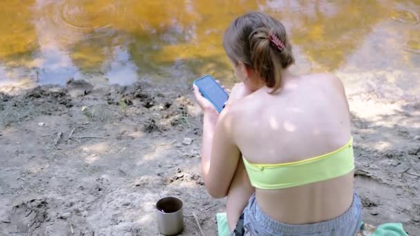 Doğa Bir Nehrin Kenarında Oturan Akıllı Bir Telefona Mesaj Yazan — Stok video