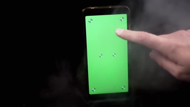 Mão Segurando Telefone Celular Com Uma Tela Verde Fundo Preto — Vídeo de Stock