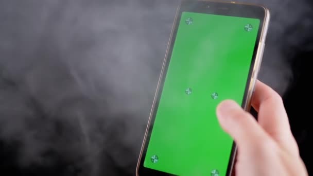 Ręczne Trzymanie Telefonu Komórkowego Zielonym Ekranem Czarnym Tle Dymie Palec — Wideo stockowe