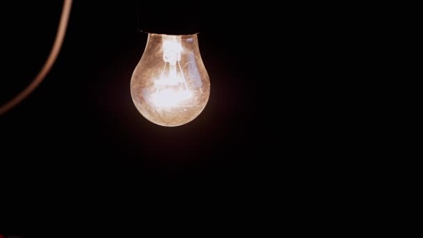 Одна Висящая Светящаяся Лампочка Проволокой Черном Фоне Пыльная Включенная Старая — стоковое видео