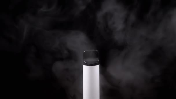 白色的电子香烟或烟卷在空旷空间的黑色背景上 电子香烟 模糊的动议 蒸汽的质感浓浓的灰烟 坏习惯 备选方案 慢动作 — 图库视频影像