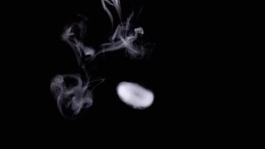 Boşlukta Düşen Beyaz Duman Halkaları Siyah Arkaplanda. Bulanık hareket. Karanlık arka plan. Kalın halkalar duman çıkarıyor. Soyut. Doku. Uçan buz bulutu, buhar. Nargile içmek ya da elektronik sigara içmek.