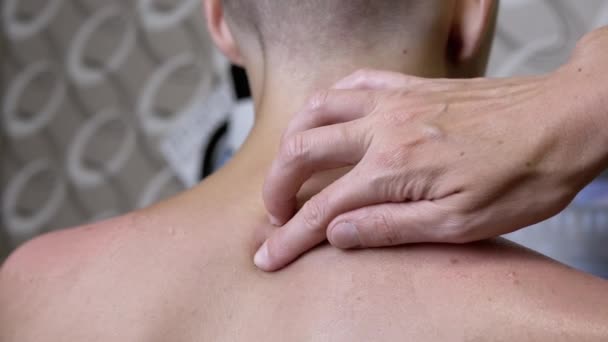 按摩师的手按摩青少年的颈椎和肩部 靠近点室内 物理疗法 手工疗法 擦拭皮肤以减轻背痛 放松背部肌肉 — 图库视频影像