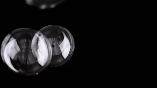 ブラックバックグラウンドで大量の液体石鹸バブルが飛ぶバースト ブローイング スプラッシュ ブラリーモーション 透明な形をしています アブストラクト フォーカス 空っぽの空間 黒と白の背景に孤立した — ストック動画