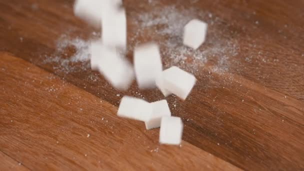 Weiße Zuckerwürfel Fallen Auf Einen Hölzernen Hintergrund Mit Brauner Oberfläche — Stockvideo