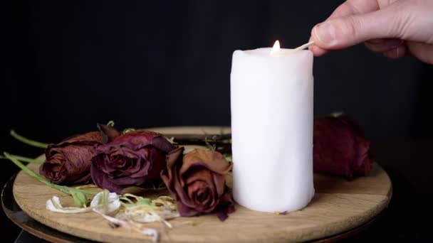 在旋转的干红玫瑰的背景下 手电筒是白色的烛光 黑色背景 干花芽的组成 悲伤的概念 死亡纪念日 — 图库视频影像