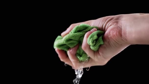 Hand Knijpt Een Natte Groene Doek Met Vallende Druppels Water — Stockvideo
