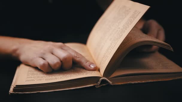 夜に暗い部屋で古い本を読んでいる少女 インド人 フリッピングページ 女性が本の黄色いページに指をかける 神秘的な雰囲気 ブラックバック ライフスタイル イブニング — ストック動画