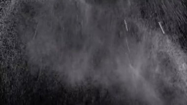 Buz Damlaları 'nın Patlayan Akıntısı, Kara Arkaplanda Boşlukta Toz. Spreyle. Soyut. Doku. Toz, toz ve sudan oluşan dinamik parçacıkların parlaması. Döndür, döndür. Bulanık hareket. Kozmos.