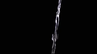 İzole edilmiş Siyah Arkaplan 'a akan şeffaf Temiz Su Akıntısı. Bir su jeti ışıkta parlar ve parlar. Döndür. Düşen suyun yavaş hareketi. Temiz su için. Çay, kahve..