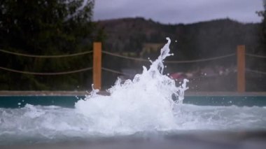 Dışarıdaki termal kaplıcalardan gelen sıcak suyla kaynayan jakuziyi boşalt. Bir damla su, köpüklü çeşme. Jakuzi, Carpathian dağları manzaralı yüzme havuzu. Spa tedavisi. Sağlık Oteli.