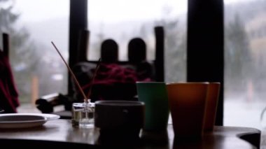 Doğanın Bulanık Arkaplanı 'nda Panoramik Pencereli Bir Otelin İçinde Görüntü. Siluet. Mobilyalı spa odası, servis masası, tabaklar, bardaklar, aroma çubukları, sandalyeler. Havuz manzaralı. Işık. Günaydın..