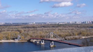 Kyiv 'in panoramik manzarası, Dinyeper Nehri, Uyuyan Alanlar ve Footbridge. Metropolis 'teki yeşil adaya giden cam köprüden görüntü. Bulut manzarası, yeşil ağaçlar. Kyiv Ukrayna 'nın başkentidir..