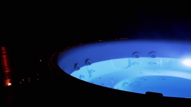 空豪华户外热管 夜间有霓虹灯在酒店温泉台 用来自温泉的热水游泳池或按摩浴缸 摇曳蓝灯 水蒸发 健康假期 — 图库视频影像